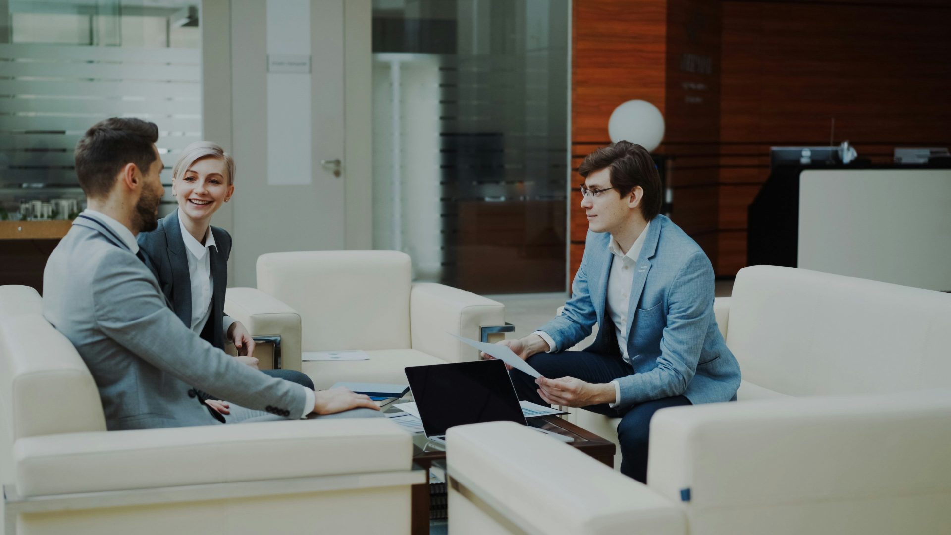 Three professionals in a modern office lounge